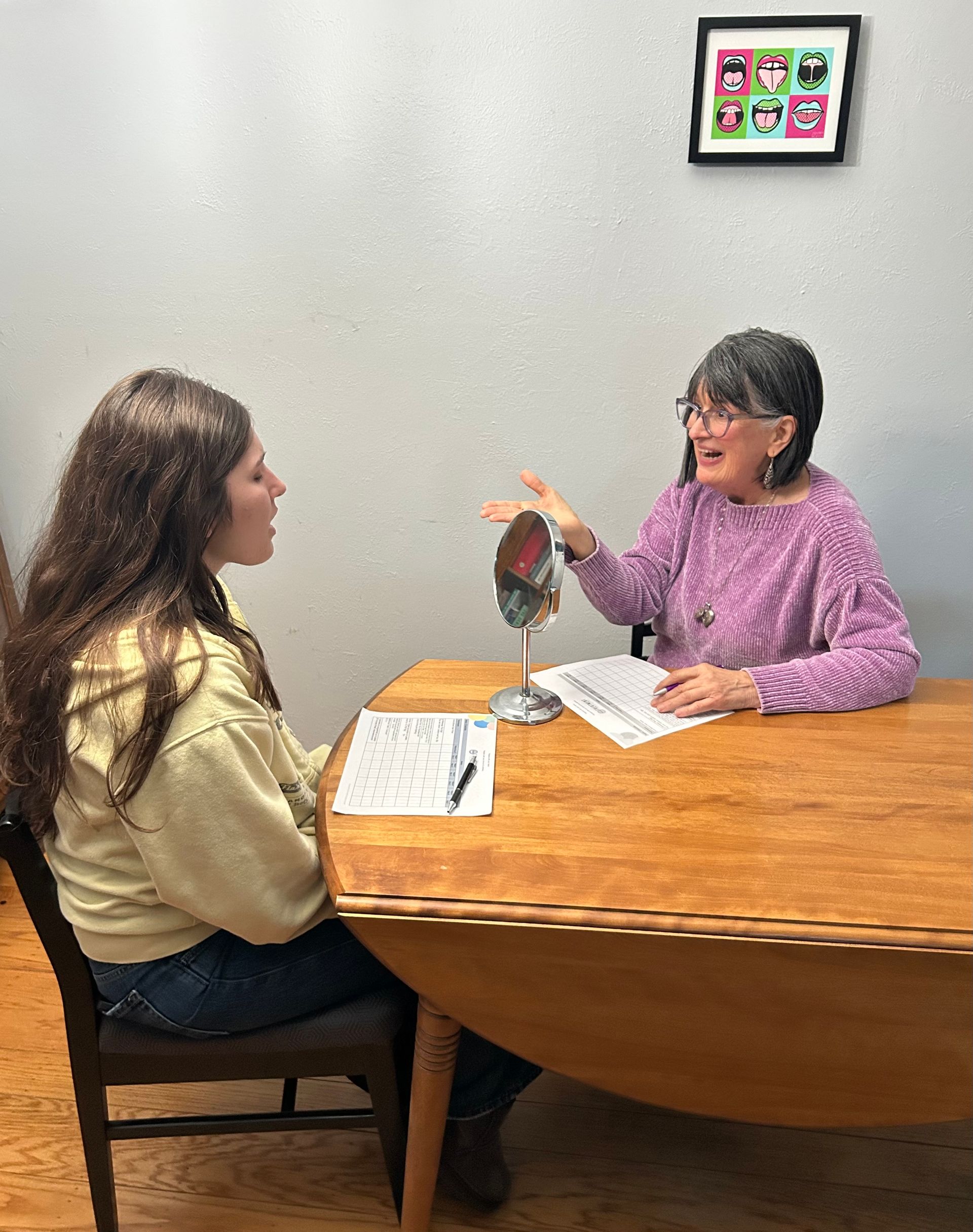 Son kissing mother's cheek; both smiling outdoors.