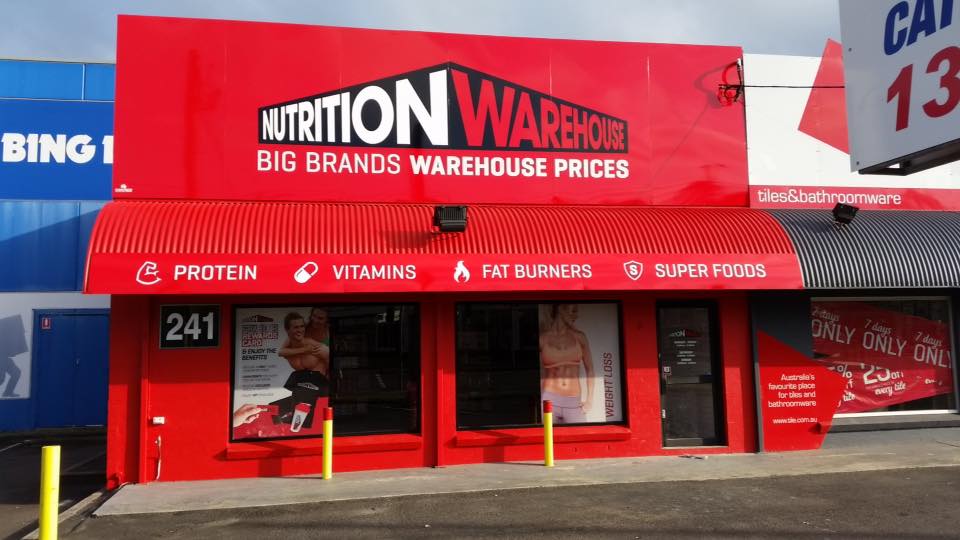 Red Nutrition Warehouse storefront with signage, awning, and products listed below.