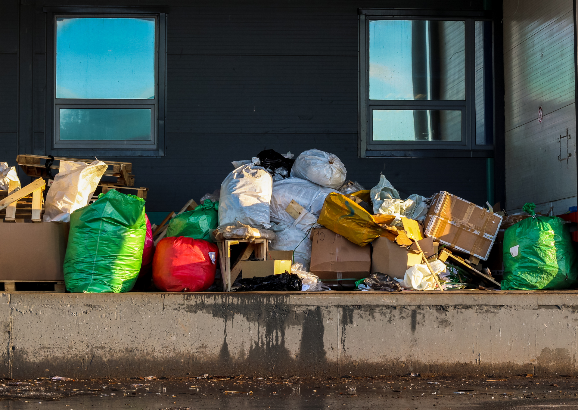 A pile of trash is sitting on the side of a building.