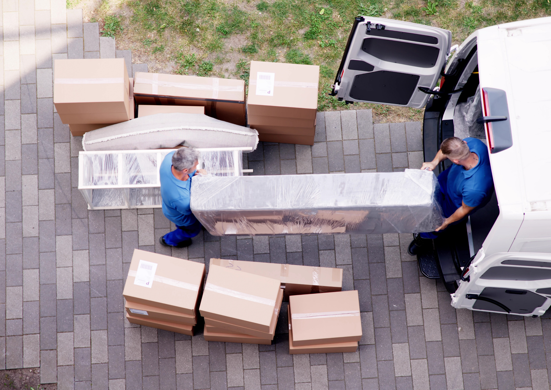 Two men are loading boxes into a van.