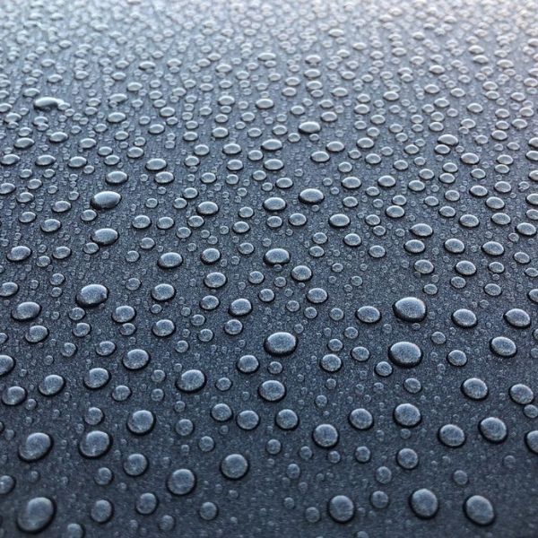 Water beading effect from hydrophobic Gtechniq ceramic coating on vehicle paint surface.
