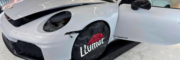 White sports car receiving LLumar paint protection film installation.