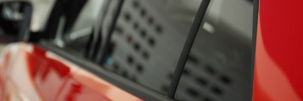 Close-up of tinted vehicle windows with LLumar no-fault replacement coverage.