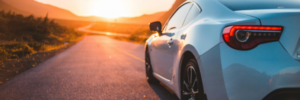 Vehicle on the road comparing paint protection film and ceramic coating benefits.