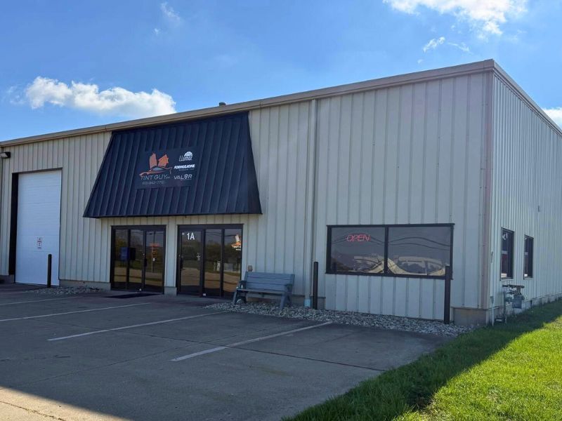 Exterior of Tint Guy; a parking lot in front and where to enter to get window tinting or PPF services.