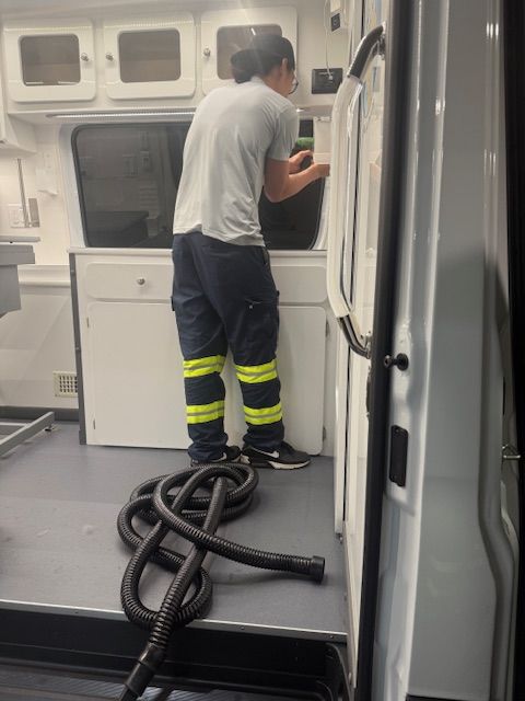 Person in safety pants inside a fleet vehicle. A hose is on the floor.