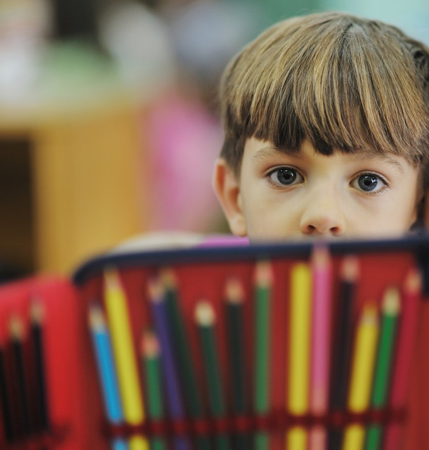 child holding colored pencils