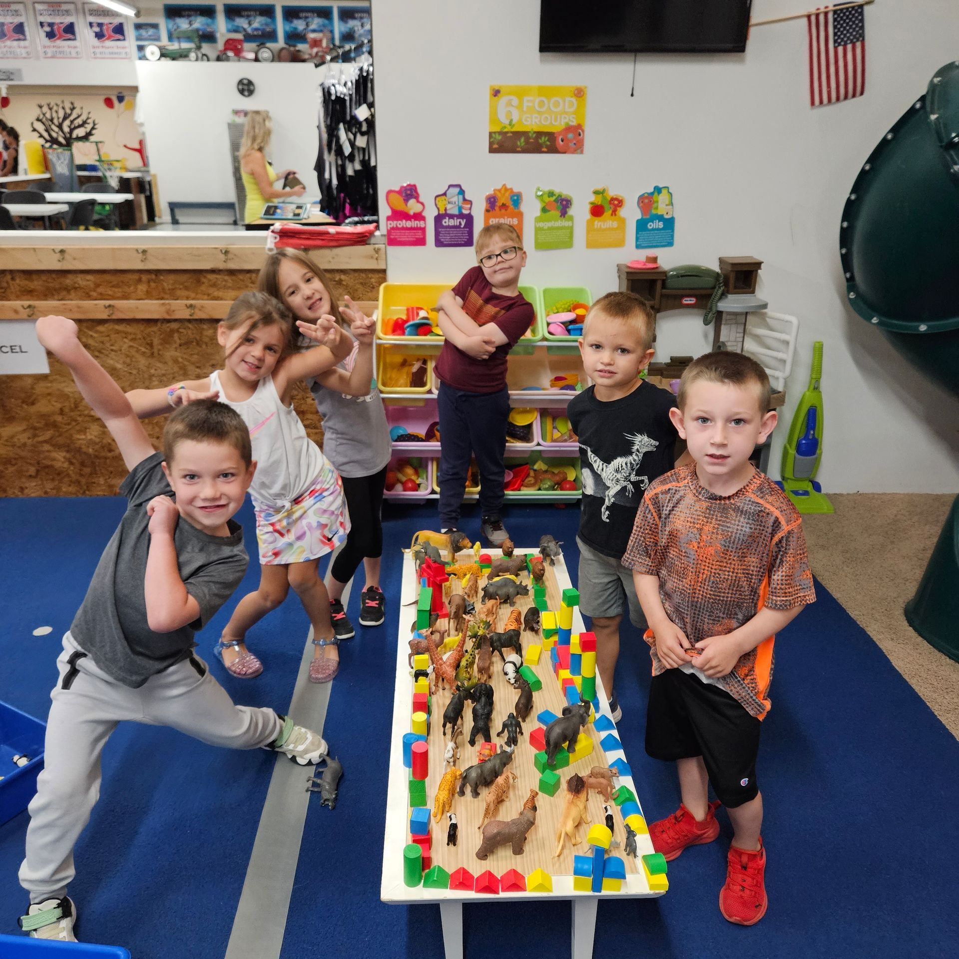 A group of children standing around a table with animals on it