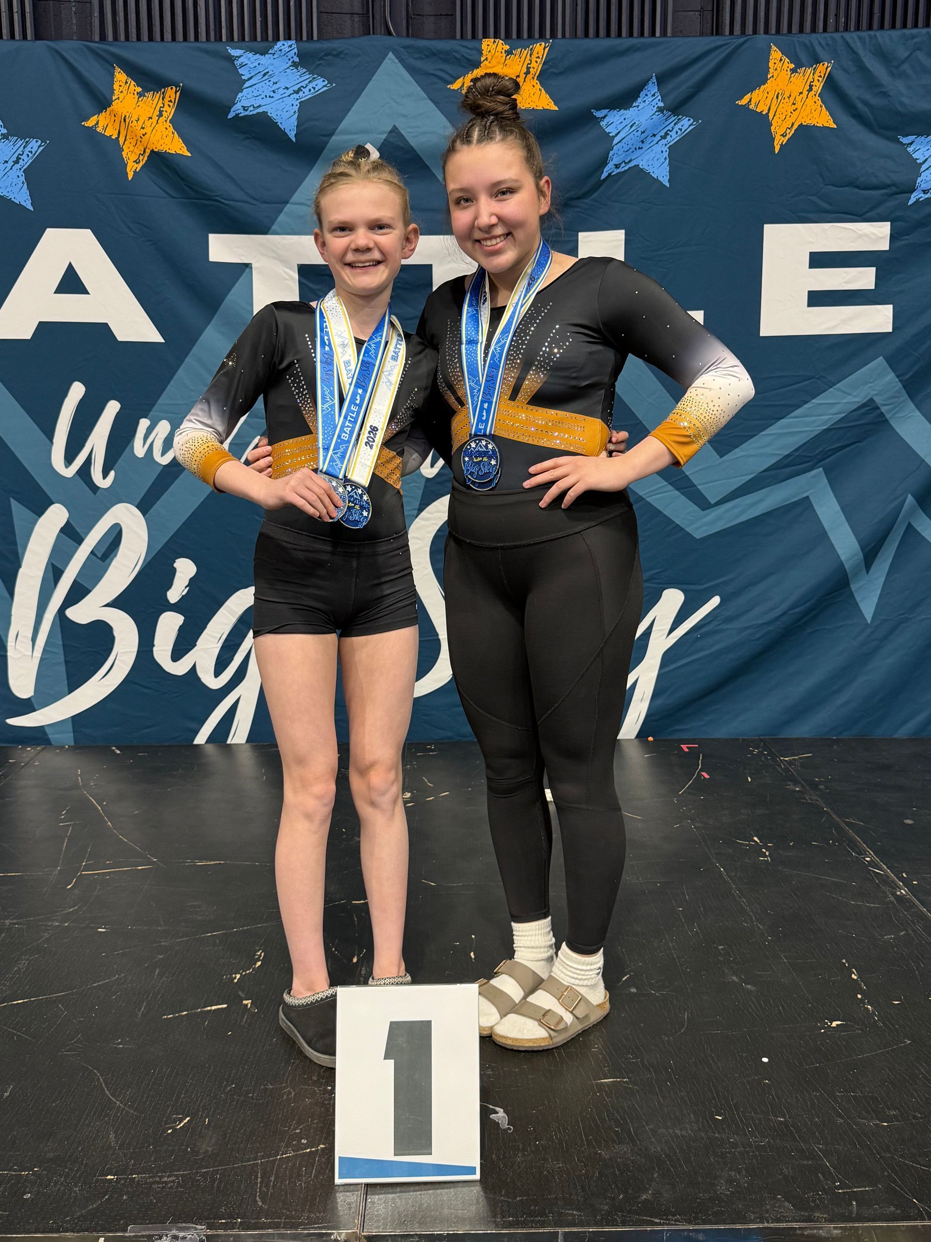 A group of gymnasts are raising their hands in the air