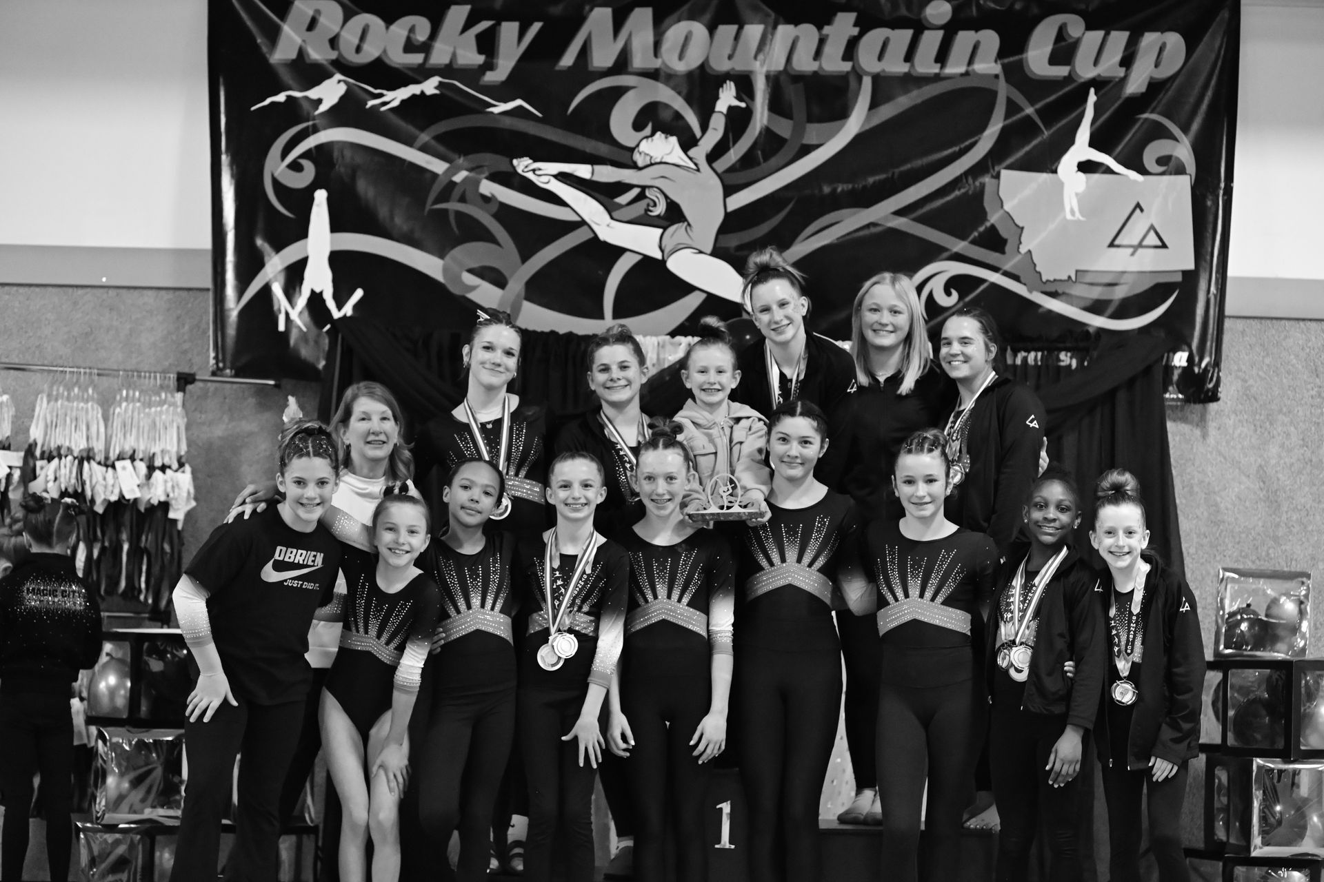 A group of girls are standing on a podium holding a sign that says 2024 1st place team