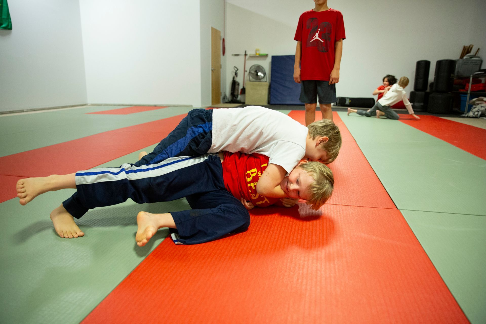 A man and a girl in karate uniforms are talking to each other.