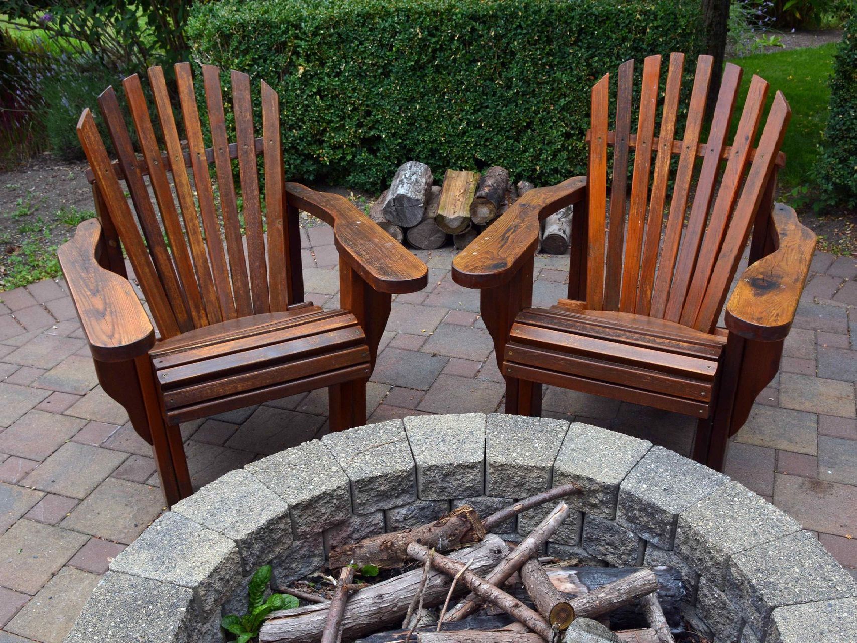Two empty brown chairs in front of a gray rounded fire pit