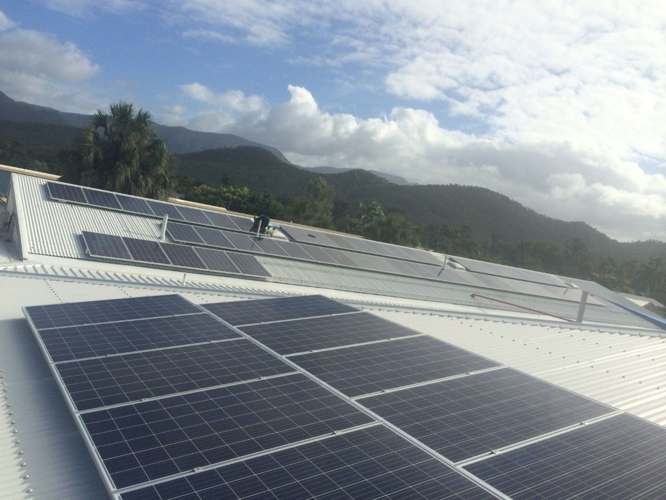 Man Installing A Solar Panels On Roof — Mission Solar And Electrical In Mission Beach, QLD