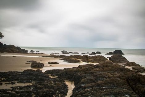 A Rocky Beach With A Cloudy Sky In The Background  — Mission Solar And Electrical In Innisfail, QLD