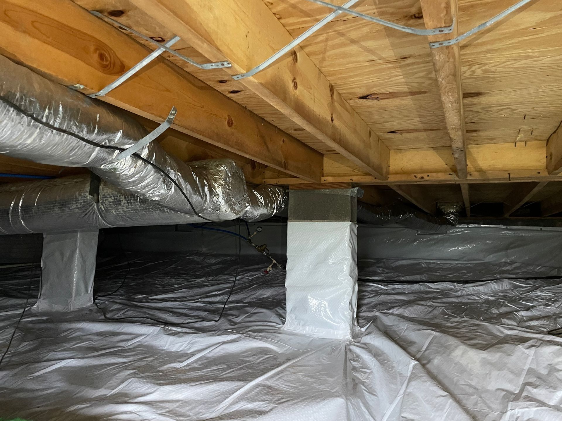 The foundation of a house is covered in plastic.