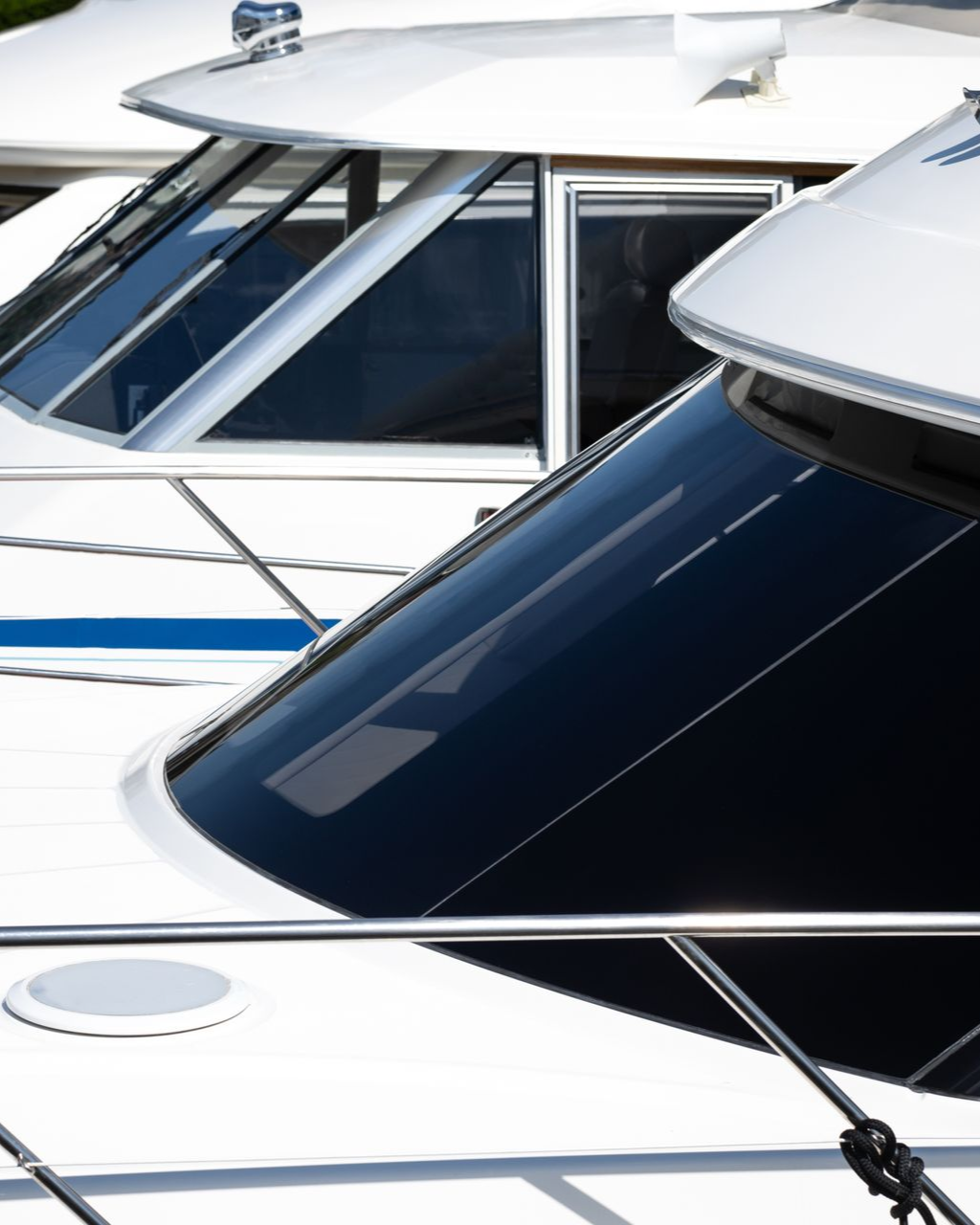 White boats with dark tinted windows, docked.