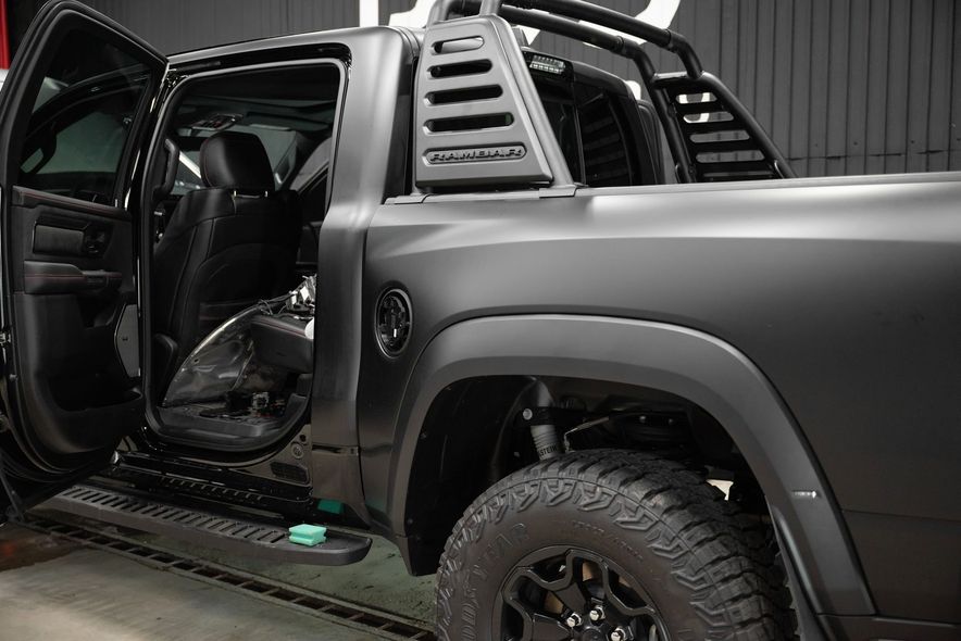 A car is being washed with foam in a garage.