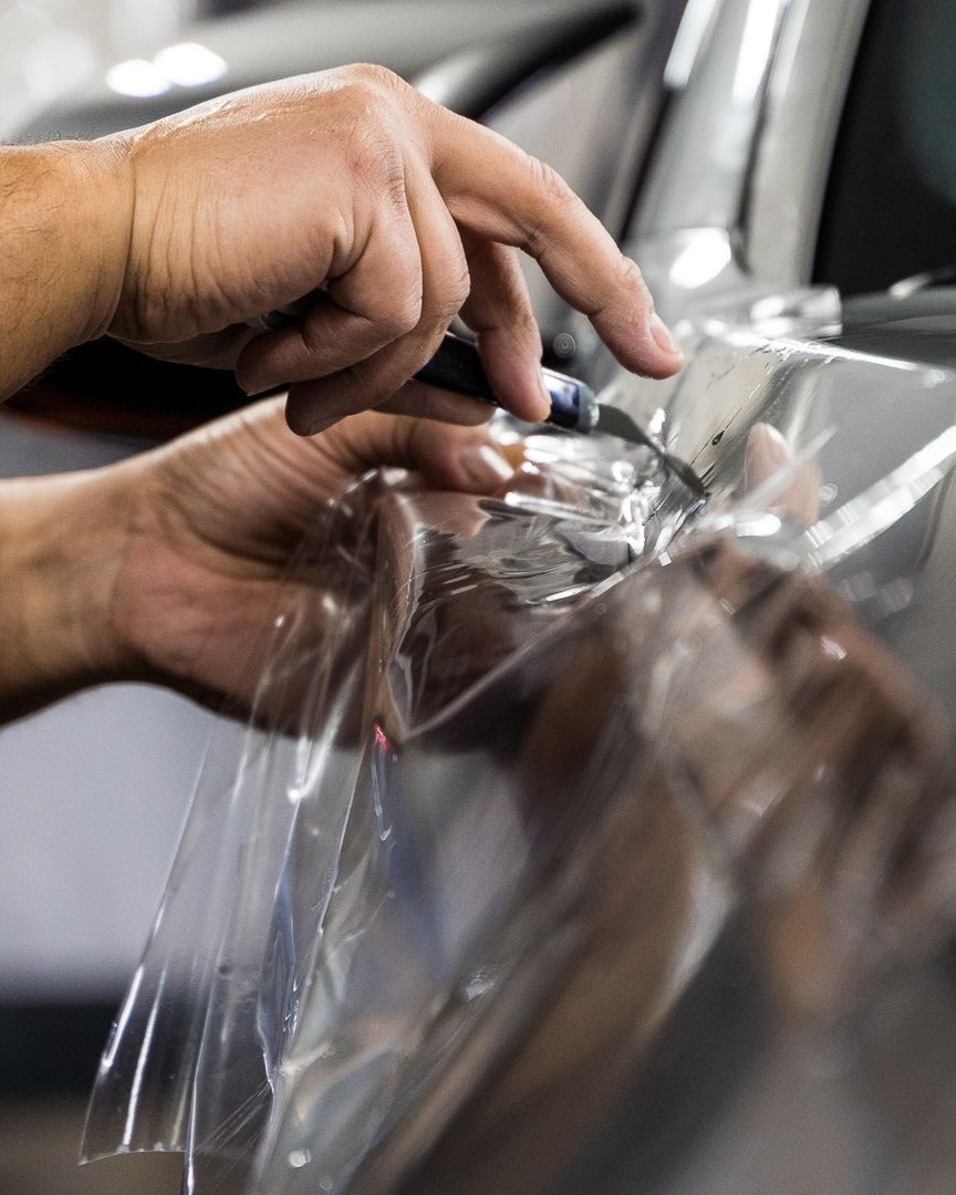 A person is washing a car wheel with foam