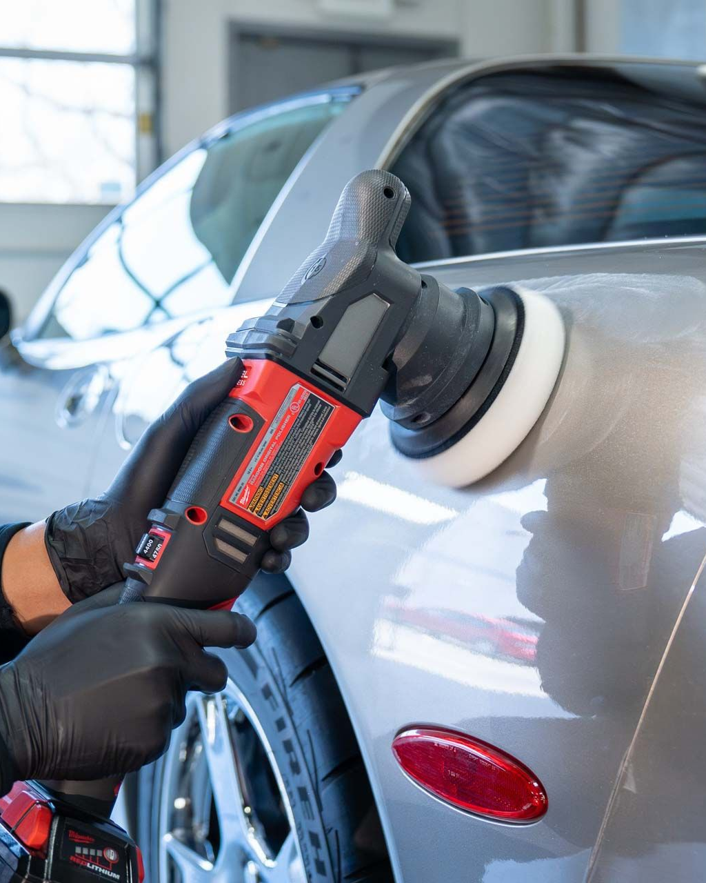 A person is wrapping a car with clear plastic