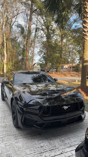 Sleek black Ford Mustang with paint protection film on the front bumper and hood
