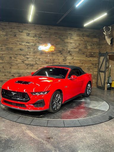 Bright red Ford Mustang convertible with paint protection film in a showroom