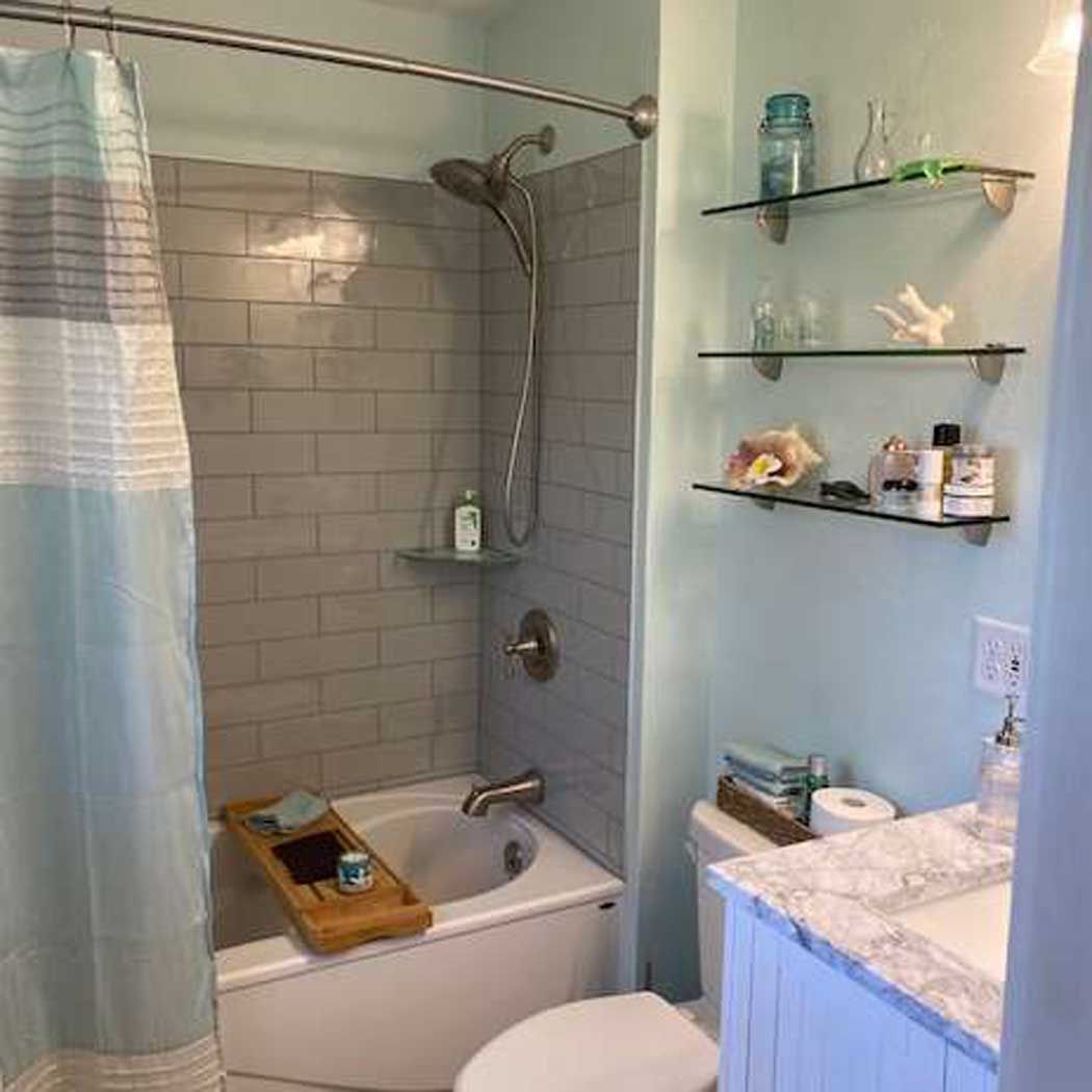A bathroom with a tub , toilet , sink and shower.
