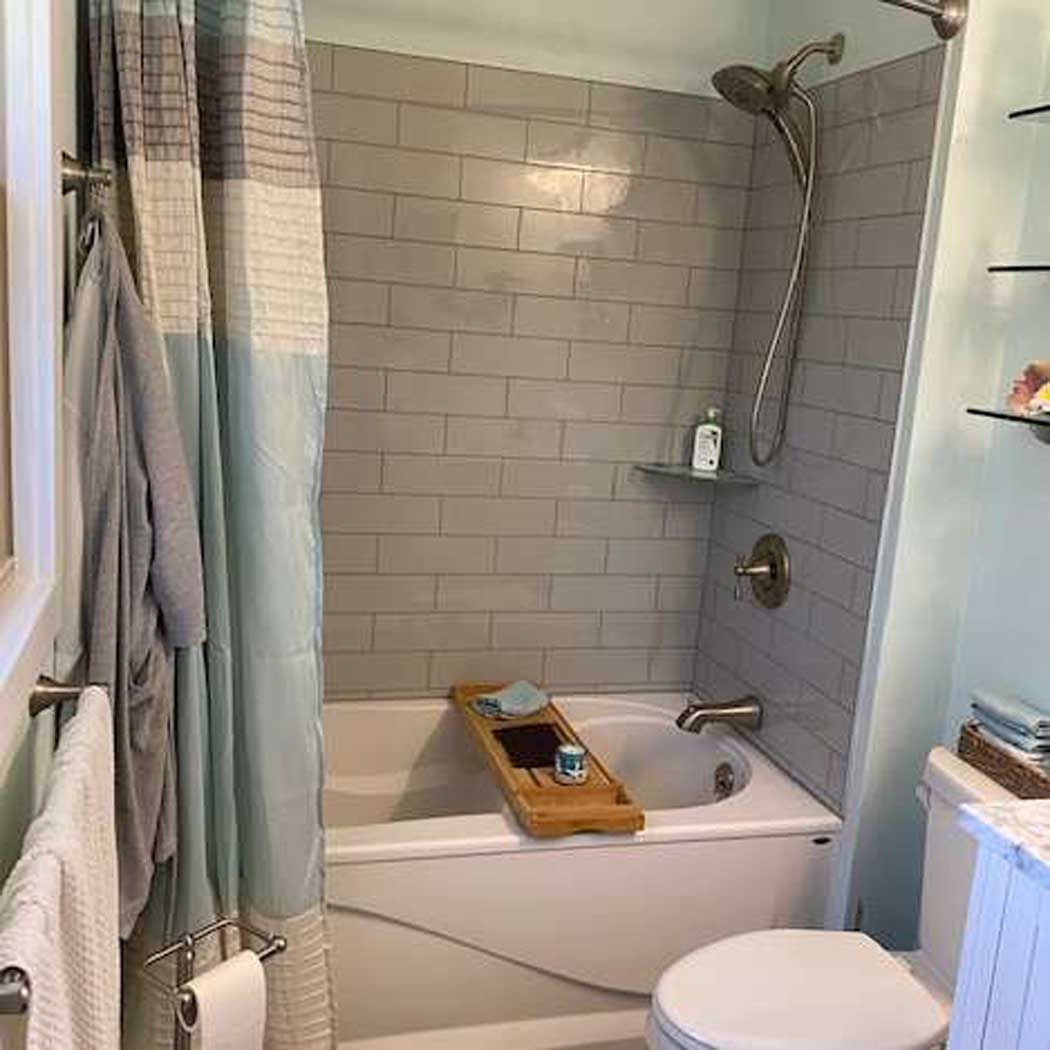 A bathroom with a tub , toilet and shower.