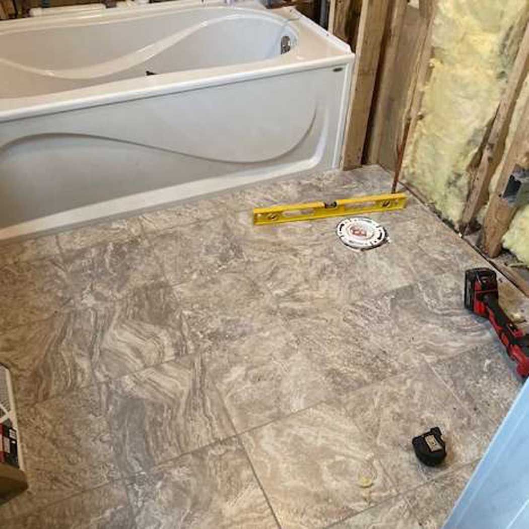 A bathtub is being remodeled in a bathroom.