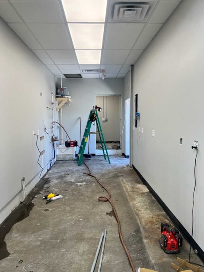 A long hallway with a ladder in the middle of it.