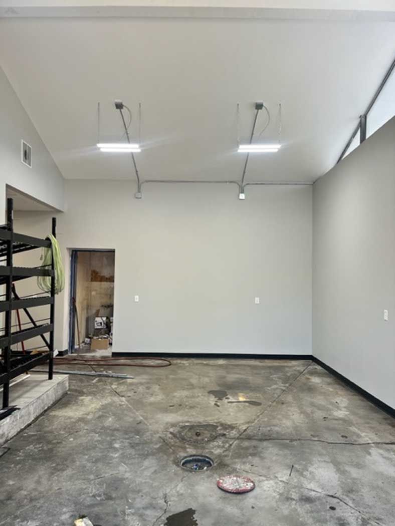 An empty garage with a concrete floor and white walls.