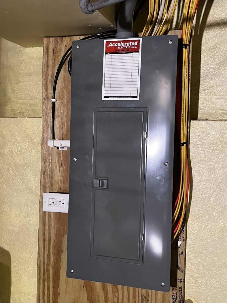 A electrical box is hanging on a wooden wall.