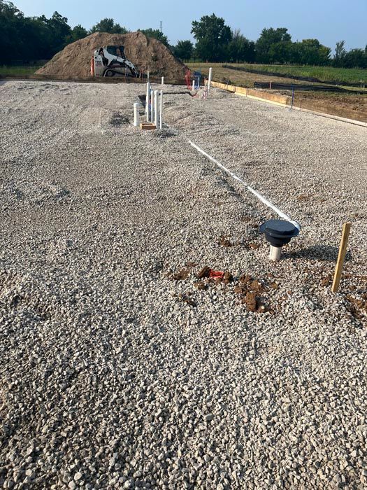 A gravel road with a pile of dirt in the background.