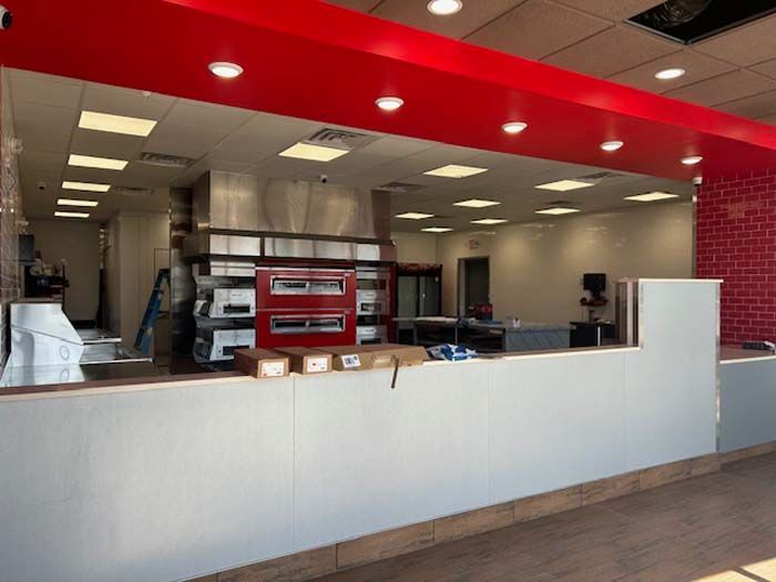 The inside of a pizza restaurant with a red ceiling.