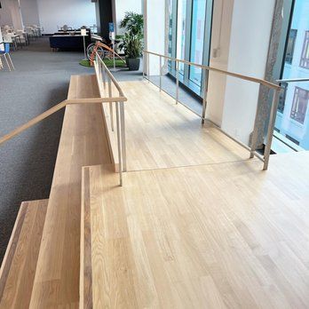 A wooden staircase with a metal railing in a room.