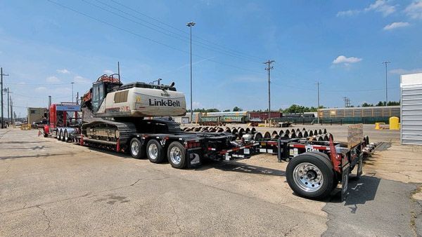 A large excavator is being transported on a trailer.