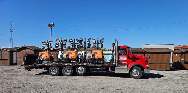 A red semi truck is parked in a parking lot.