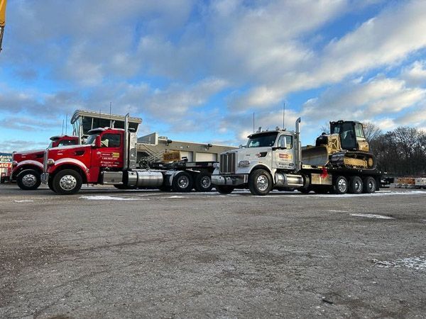 Two semi trucks are parked next to each other in a parking lot.