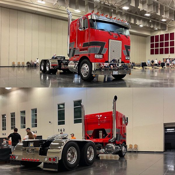 A red semi truck is parked in a large building