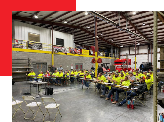 A group of people are sitting at tables in a large room.