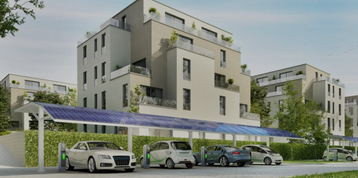 A group of cars are parked under a solar canopy in front of a building.