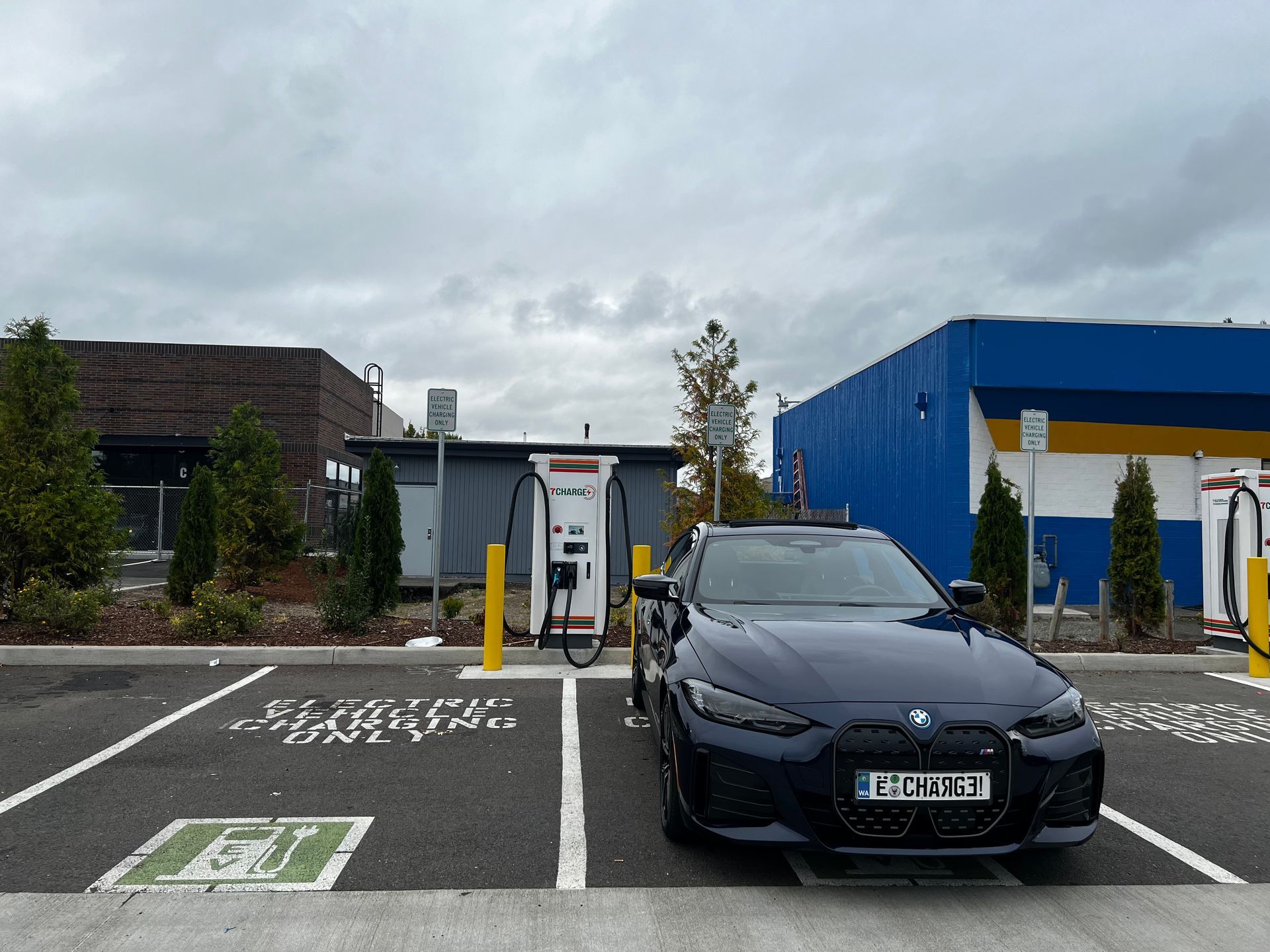 A bmw is parked in a parking lot next to a charging station