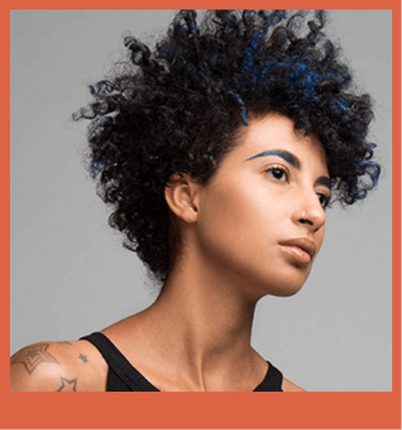 A woman with curly hair and blue streaks is wearing a black tank top.