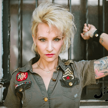 A woman in a military uniform has a tattoo on her arm