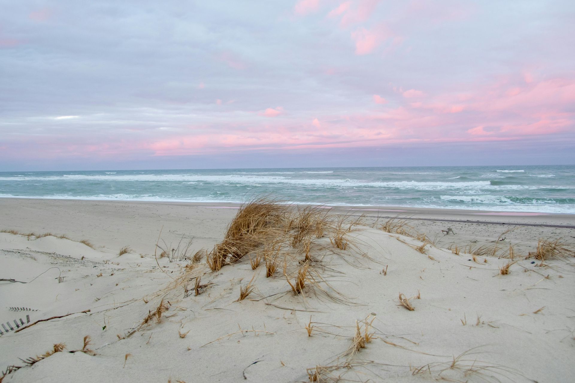 A sandy beach with a sunset in the background