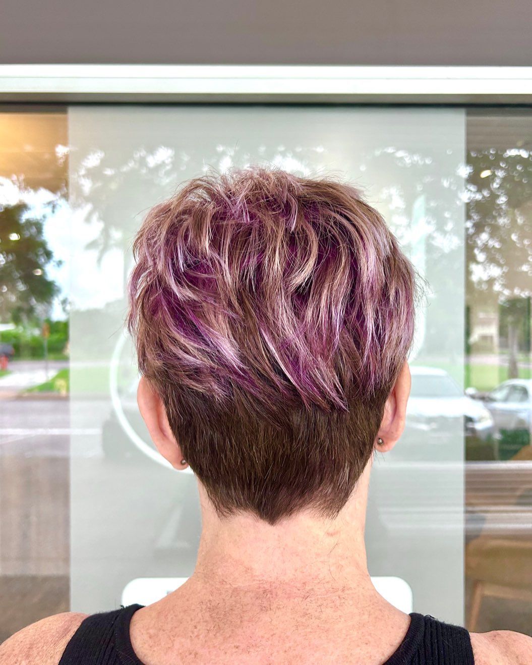 A Woman With Short Purple Hair Is Standing In Front Of A Window — Carlee Hair Design In Anula, NT