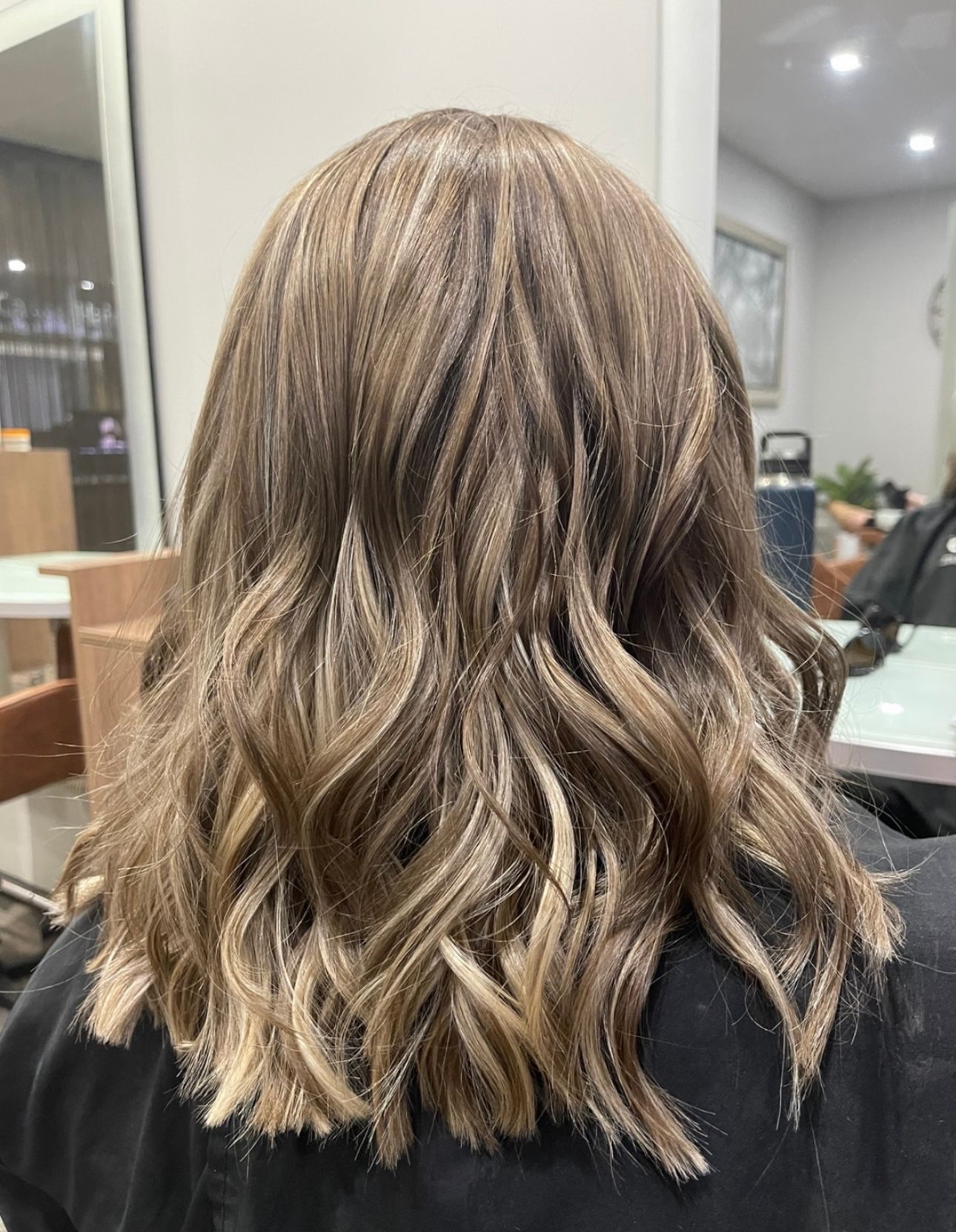 The back of a woman's hair with highlights and curls — Carlee Hair Design In Anula, NT
