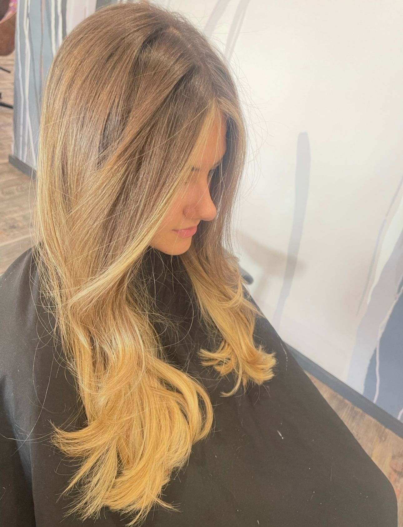 A woman is sitting in a chair with long blonde hair — Carlee Hair Design In Anula, NT