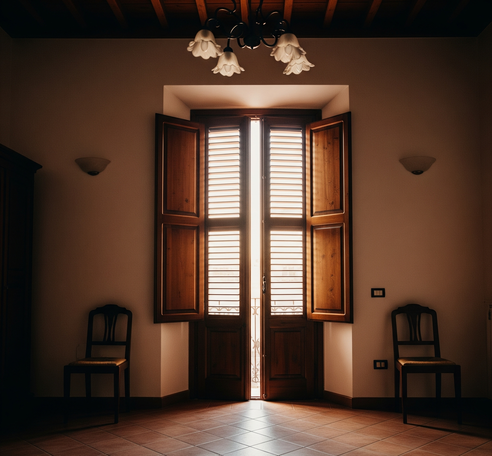 Una stanza con due sedie e una finestra con le persiane aperte