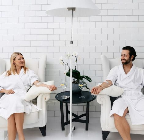 A man and a woman are sitting in chairs talking to each other.