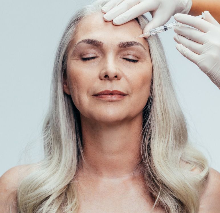 A woman is getting an injection in her face at a beauty salon.